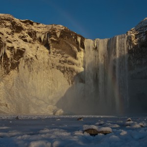 skogafoss waterfall frozen in iceland