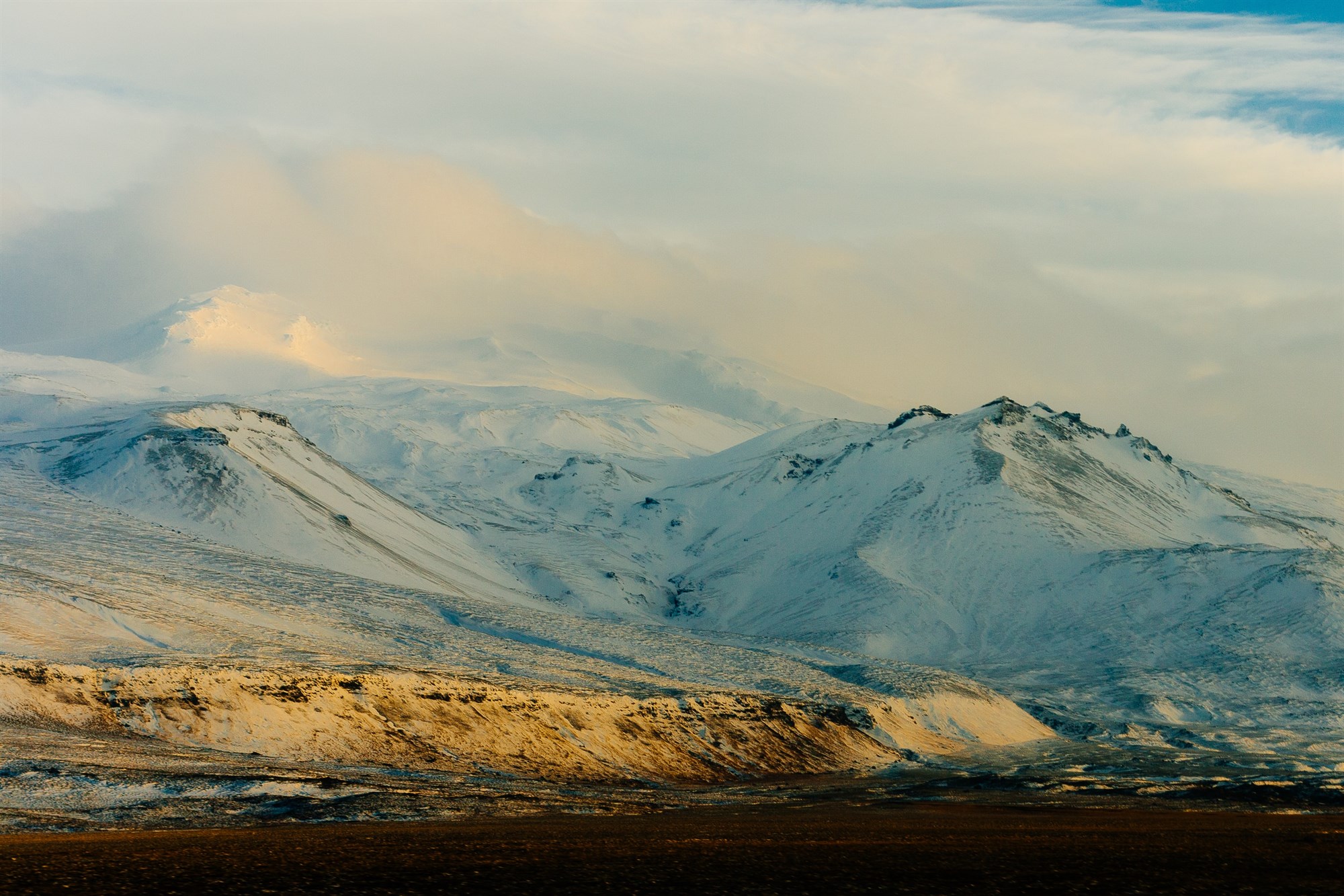Panoramic view of the snow-covered Snæfellsjökull volcano and surrounding mountains in Iceland