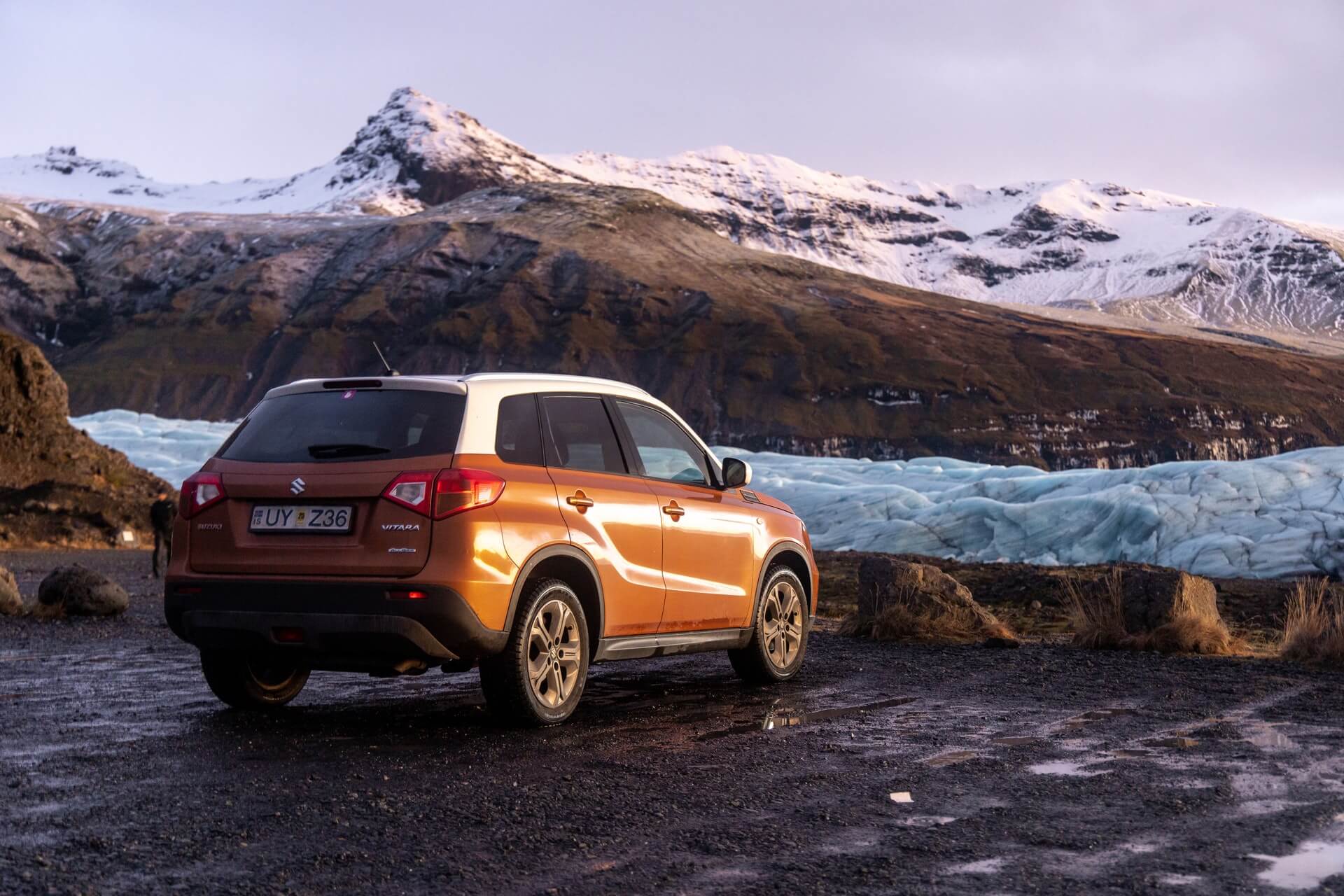 Parked vehicle overlooking snow-covered mountains in Iceland